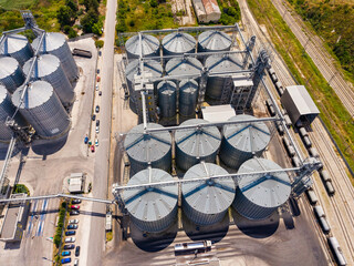 Grain storage facility in a rural area with silos and nearby train tracks © DSMT