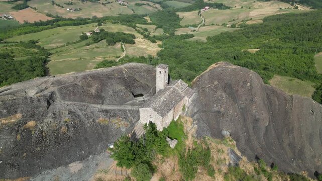 Europe, Italy, Travo , Drone aerial view Pietra Perduca is a  volcanic rock with the  church set in stone immersed in a  countryside landscape with cultivated land in Val Trebbia Bobbio Emilia Romagna