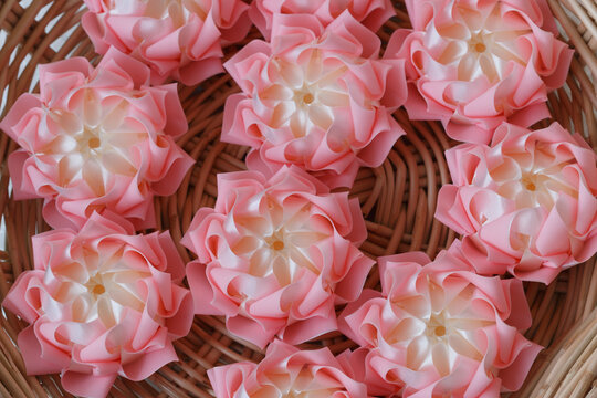 Handmade craft Thai festival decoration,Coins wrapped in floral ribbons on a basket against a white background.