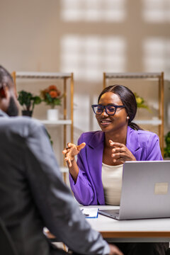 African corporate woman professional conversing with a male colleague in an office