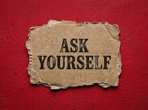 Ask yourself text on torn cardboard, concept of introspection and self-reflection, on a textured red background, representing thoughtful contemplation.