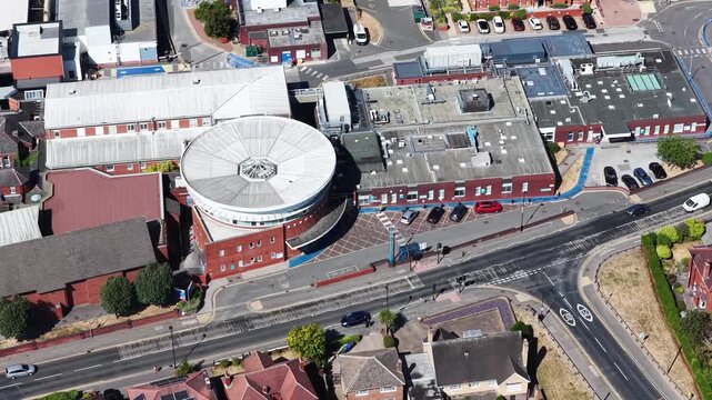 Aerial footage of Mexborough Montagu Hospital in South Yorkshire England showing the distinctive circular hospital building surrounding healthcare facilities nearby roads and residential neighbourhood