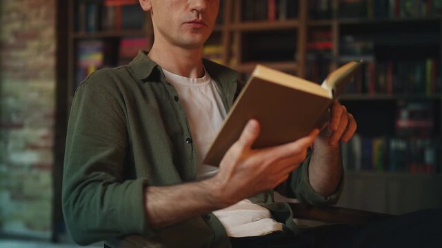 Focused young male historian studying literature in library, reading hobby