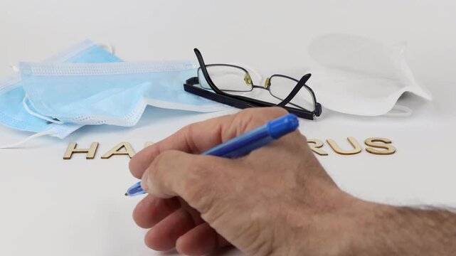 HANTAVIRUS written on a white background. A man's hand writing with a ballpoint pen, a healthcare and medical concept