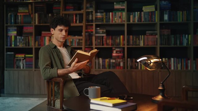 Young man reading historical literature in a library, education and hobby