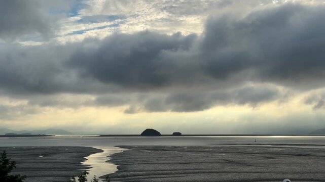Dramatic Clouds Over Tidal Flat with Distant Islands and Water Stream
