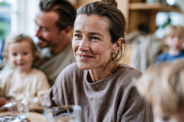 Obraz premium A joyful woman smiles brightly during a family gathering, engaging in laughter and meaningful conversations that illustrate the importance of family bonds and shared moments.