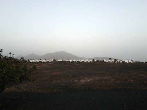 Volcanic landscape with whitewashed village near Yaiza, Lanzarote, Canary Islands, Spain