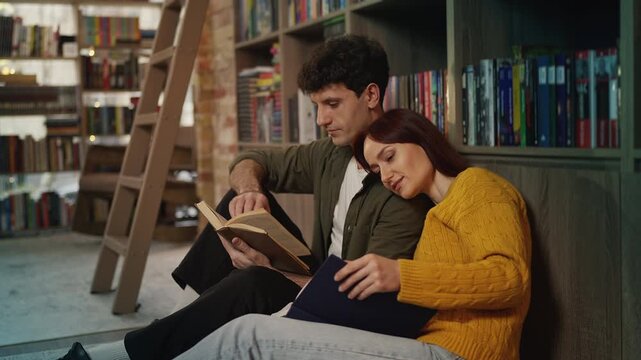 Relaxed young couple enjoying books and conversation in modern bookstore