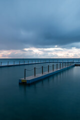 Fototapeta premium Cloudy view of South Curl Curl rock pool in the morning, Sydney, Australia.