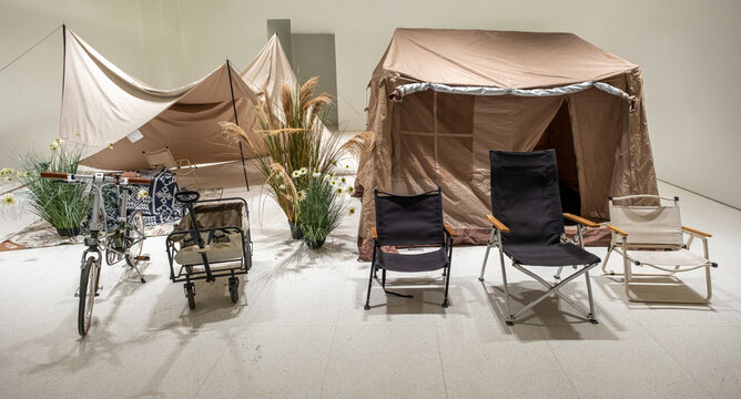 a curated collection of outdoor camping gear, emphasizing a neutral color palette with stark black accents for a modern look