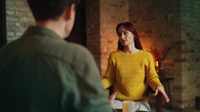 Displeased red-haired woman arguing with boyfriend during restaurant date