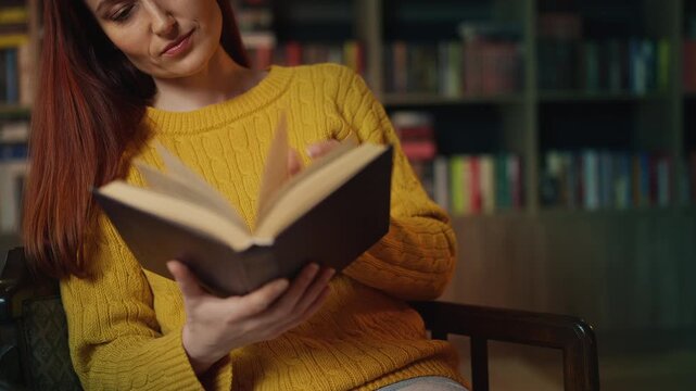 Happy young woman reading favorite book and smiling in library, enjoying leisure