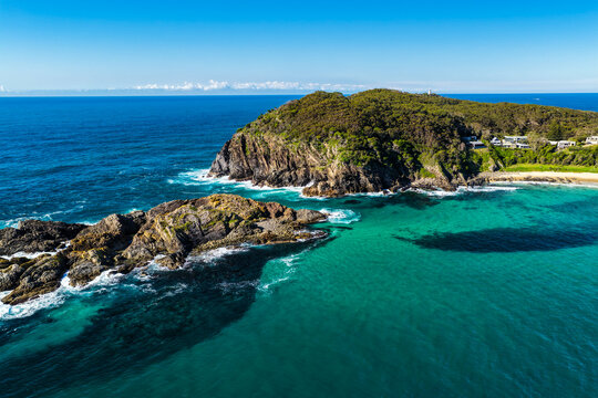 Aerial view of Sugarloaf Point surrounded by crystal-clear turquoise waters and the rugged coastline at Seal Rocks, NSW, Australia, highlighting the natural beauty of this iconic coastal headland.
