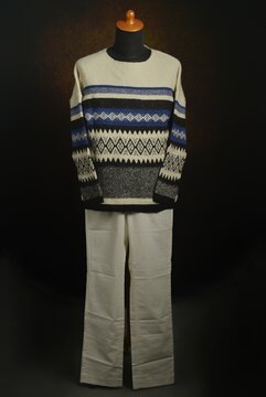 Fair Isle sweater and white trousers on a display mannequin