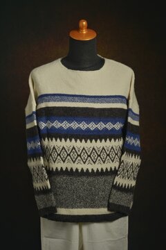 Fair Isle sweater and white trousers on a display mannequin