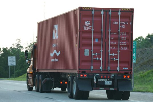 Pennsylvania, U.S.A - Jul 19, 2026 - The red ICL shipping container on semi‑truck displaying weight, capacity, and identification details while traveling on a highway.