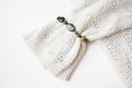 Close-up of a knitted sweater with a natural jasper bracelet