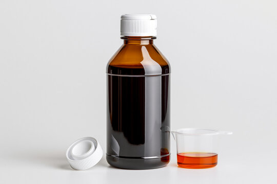 Pharmaceutical Oral Syrup Bottle with Measuring Cup Isolated on White Background