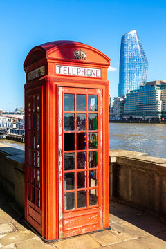 Classic Red Telephone Box beside River Thames in London, England, UK