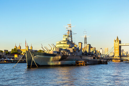 Tower Bridge and HMS Belfast Warship on River Thames at sunset in London, England, UK