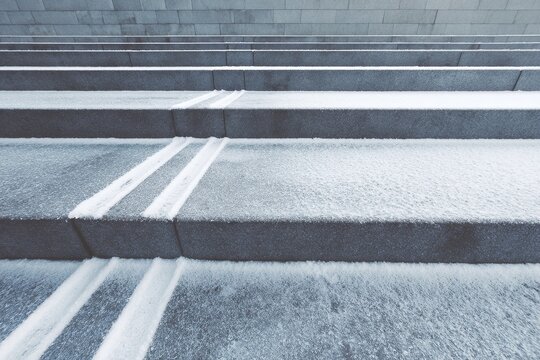 Covered in snow, gray stone stairs evoke a peaceful winter tableau, emphasizing resilience and challenge. Use this scene in travel, architecture, or seasonal themes to highlight winter's calm and
