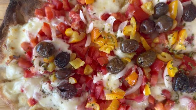 A delicious pinsa with red and yellow cherry tomatoes, mozzarella, olives, and onions