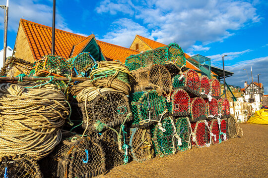 Traditional lobster, crabs pots and fishing gear on harbour quay in Scarborough, North Yorkshire, England, UK