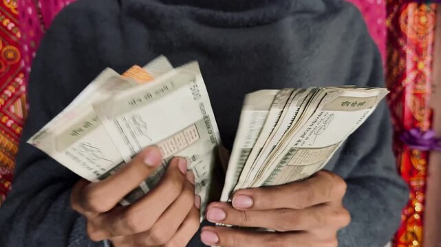 Close-up of hands counting Indian ₹500 currency notes, symbolizing corruption, bribery, illegal cash transactions, black money, financial crime, tax evasion, money laundering, and unethical business.