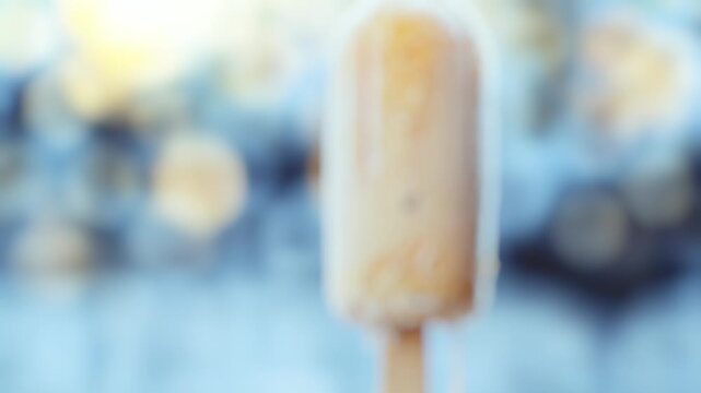 A close-up shot of a colorful popsicle stuck to a wooden stick, ready to be enjoyed