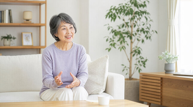 穏やかな笑顔でインタビューに答える親しみやすい日本人シニア女性
Friendly senior Japanese woman answering an interview in a bright modern living room