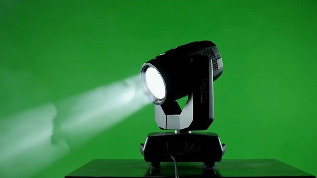 Professional Light Beam Projector on Green Screen - A modern, black moving head light projector emits a bright white beam of light across a vibrant green screen backdrop.