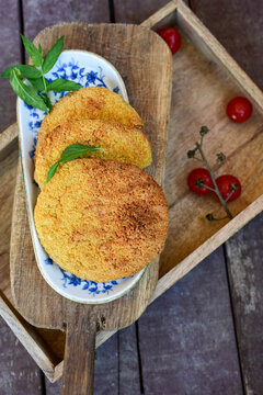 Crispy  deep fried   chicken  burgers . Breaded  with cornflakes chicken  breast fillets  with  french fires and fresh    aragula on wooden rustic background