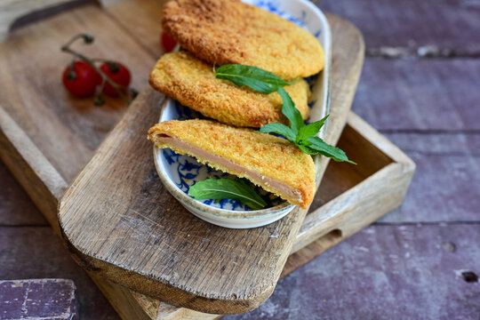 Crispy  deep fried   chicken  burgers . Breaded  with cornflakes chicken  breast fillets  with  french fires and fresh    aragula on wooden rustic background