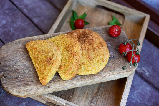 Crispy  deep fried   chicken  burgers . Breaded  with cornflakes chicken  breast fillets  with  french fires and fresh    aragula on wooden rustic background