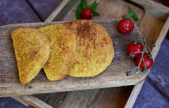 Crispy  deep fried   chicken  burgers . Breaded  with cornflakes chicken  breast fillets  with  french fires and fresh    aragula on wooden rustic background