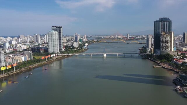 Aerial drone footage of Da Nang city skyline and the iconic bridges spanning the Han River, Vietnam. The clip features panoramic views of Dragon Bridge (Cau Rong), Tran Thi Ly Bridge, Thuan Phuoc 