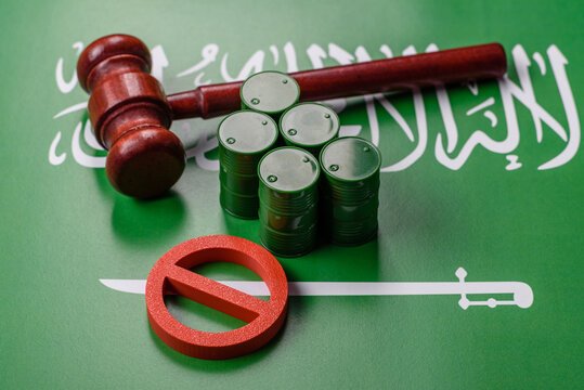 Metal barrels of oil, gas, or chemicals bearing on the flag of Saudi Arabia and a ban sign, embargo