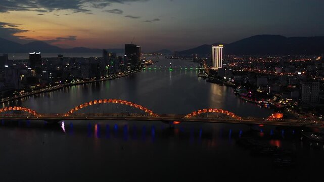 Aerial drone footage of Da Nang city skyline and the iconic bridges spanning the Han River, Vietnam. The clip features panoramic views of Dragon Bridge (Cau Rong), Tran Thi Ly Bridge, Thuan Phuoc 