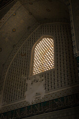 Obraz premium Historic arched window with geometric lattice and Islamic ornament inside traditional architecture in Samarkand, Uzbekistan