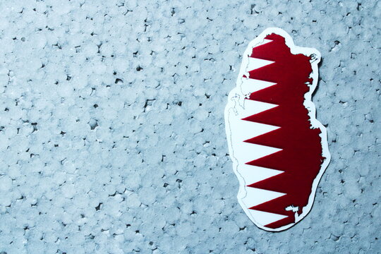 Qatar Map with National Flag Symbol on Blue Textured Background with Copy Space