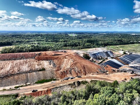 Aerial View of Active Landfill Excavation Site with Heavy Machinery and Geomembrane Liner