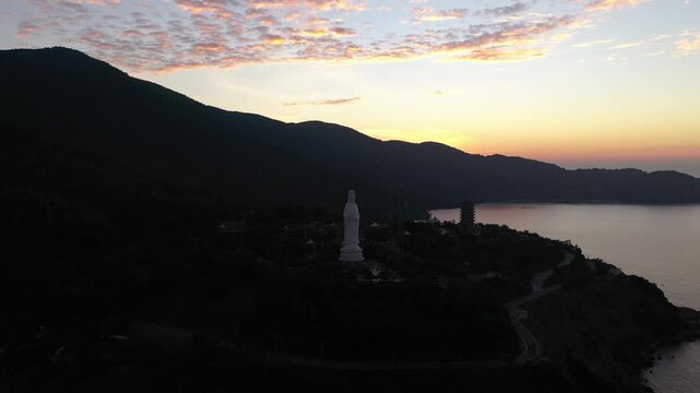 Aerial view of Linh Ung Pagoda on Son Tra Peninsula, Da Nang, Vietnam, featuring the iconic Lady Buddha statue overlooking the East Sea, surrounded by lush mountains and breathtaking coastal scenery.