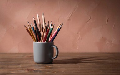 Obraz premium Many sharp colored wooden pencils arranged neatly inside a simple grey ceramic mug on wood