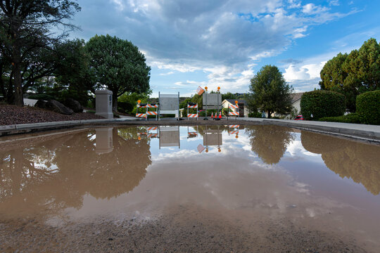Flooded Road Construction Site Reflecting Storm Clouds After Rain