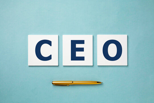 CEO spelled with letter tiles above a gold pen on a blue background representing business leadership