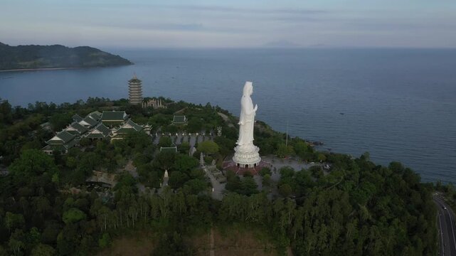 Aerial view of Linh Ung Pagoda and the iconic Lady Buddha statue on Son Tra Peninsula, Da Nang, Vietnam. Stunning Buddhist temple overlooking the sea with lush mountains and panoramic coastal scenery.