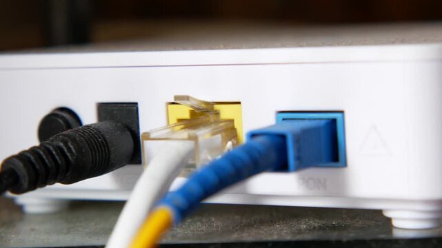Close up view of the back of a white fiber optic modem with several cables plugged into it
