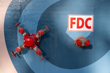 Title: Fire department connection FDC valve mounted on blue mural wall © Francisco