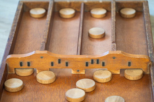 Sjoelen gameplay, classic dutch tabletop board game with wooden pucks and board called sjoelbak